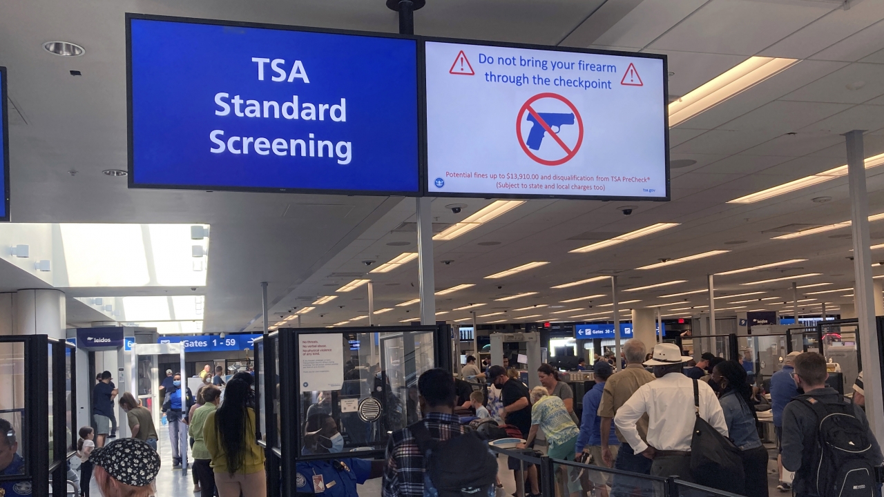 A sign warns travelers not to bring guns through a TSA checkpoint.
