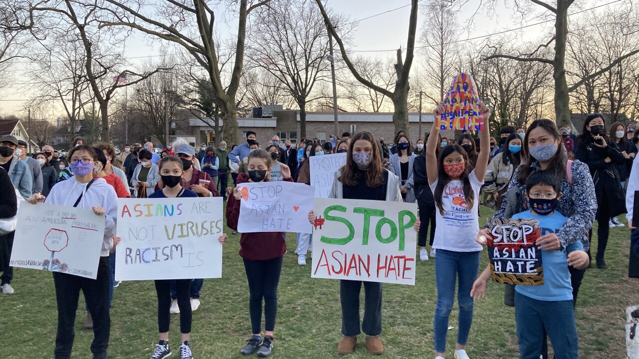 Demonstrators hold signs protesting Asian hate crimes