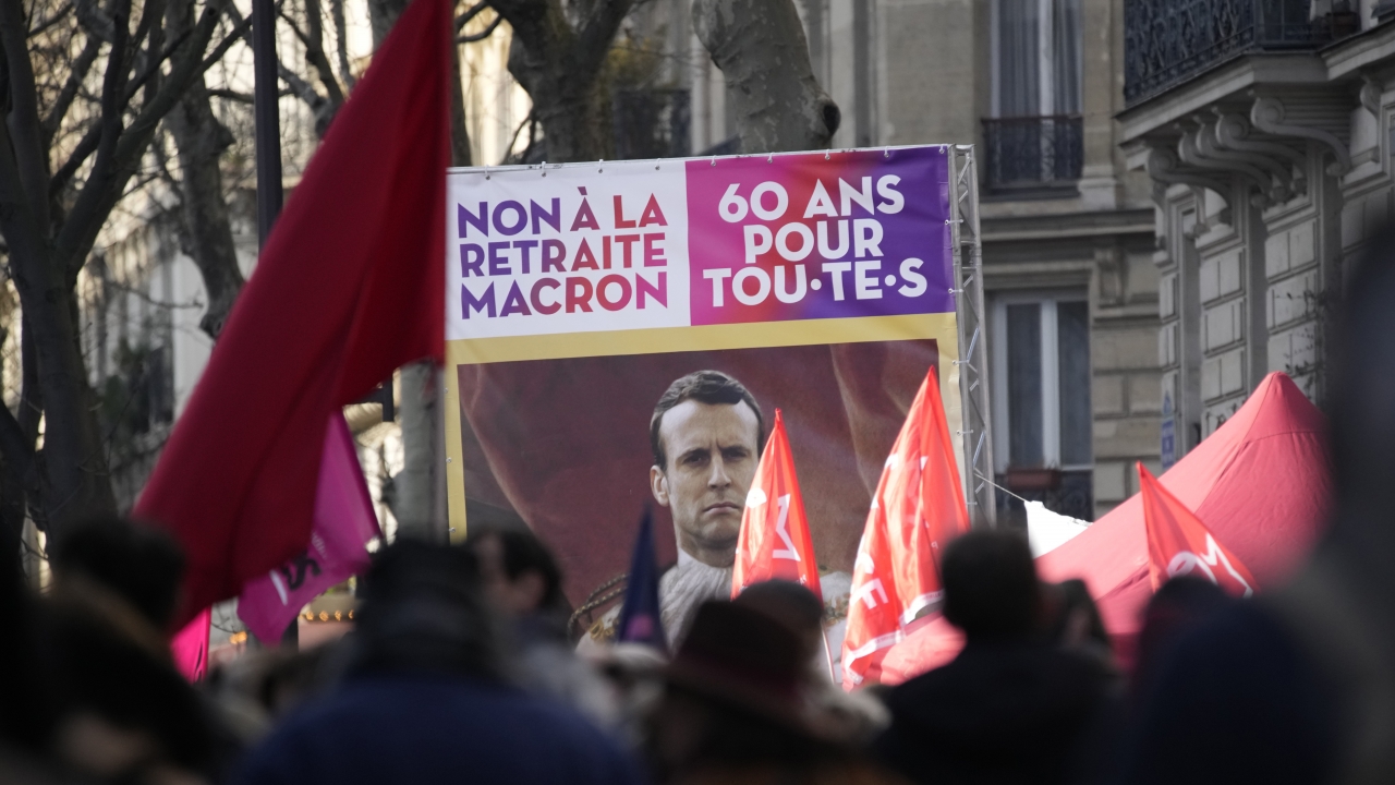 Protesters hold a banner reading: "No to Macron's retirement plan, 60 year for all" in French.