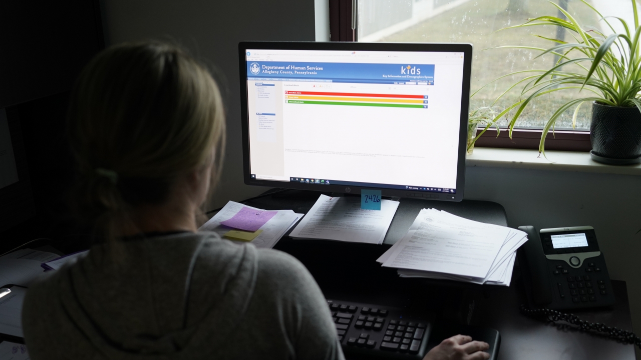 A case worker supervisor looks over software on a computer