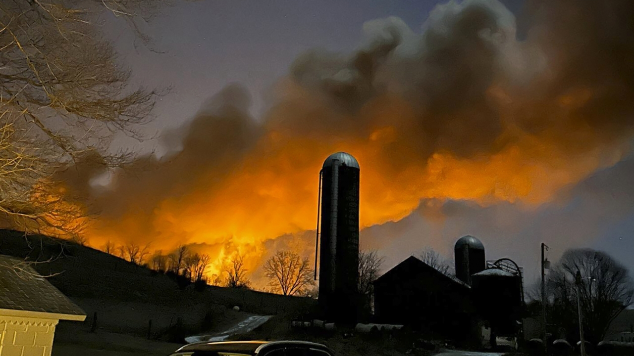 A train fire is seen from a farm in East Palestine, Ohio.