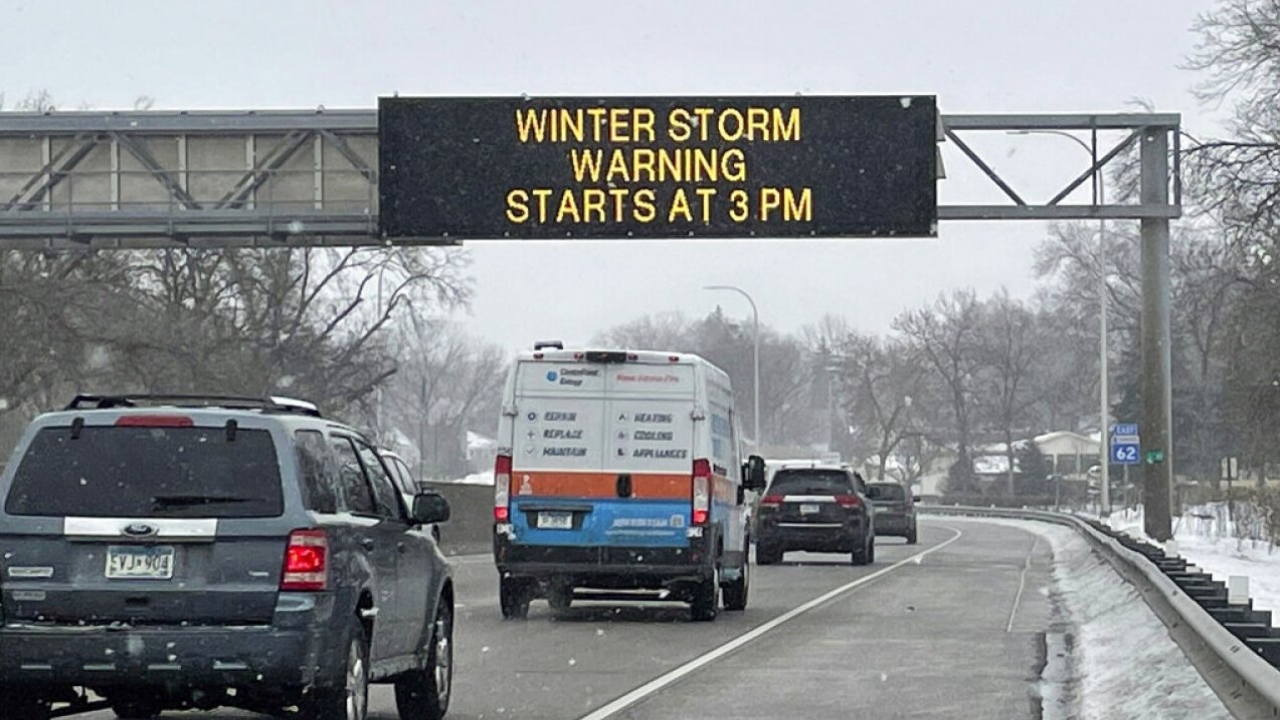 A sign that reads "WINTER STORM WARNING STARTS AT 3PM" along Interstate Highway 35 near Minneapolis-Saint Paul International.