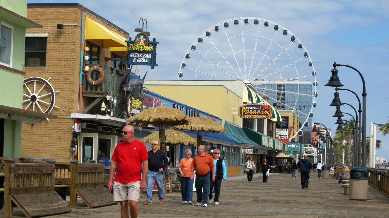Visitors walk along the boardwalk in downtown Myrtle Beach, S.C.