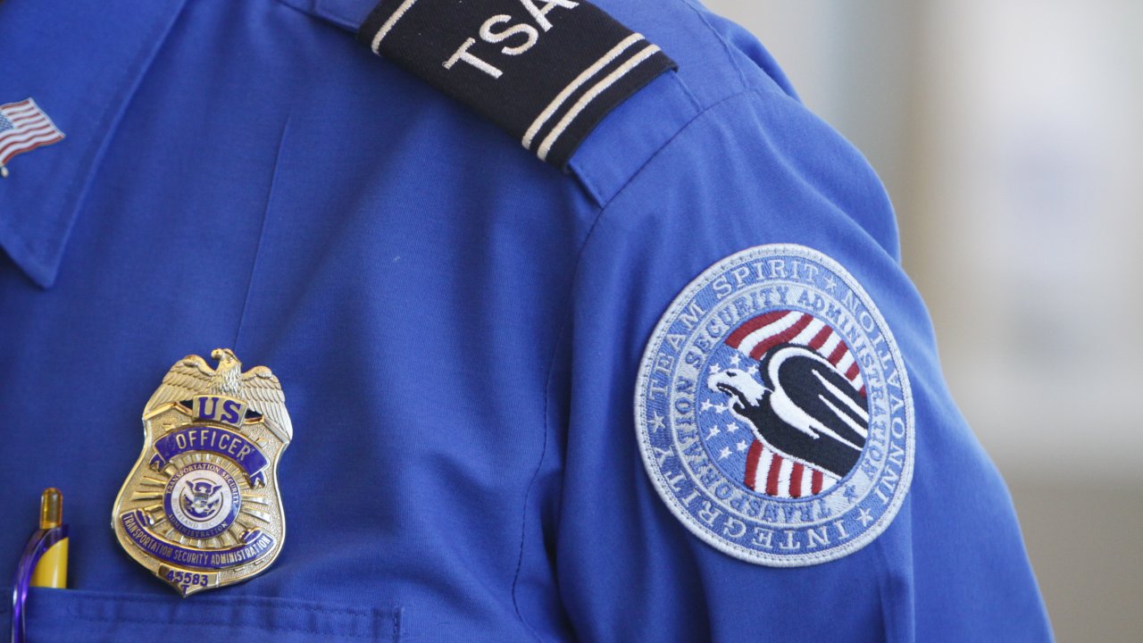 The badge and TSA logo patch are seen on the uniform of a Transportation Security Administration employee.