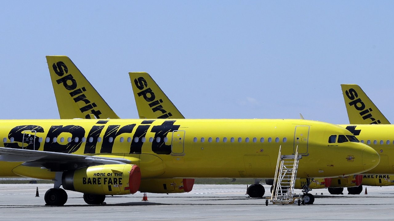 A line of Spirit Airlines jets sit on the tarmac at the Orlando International Airport