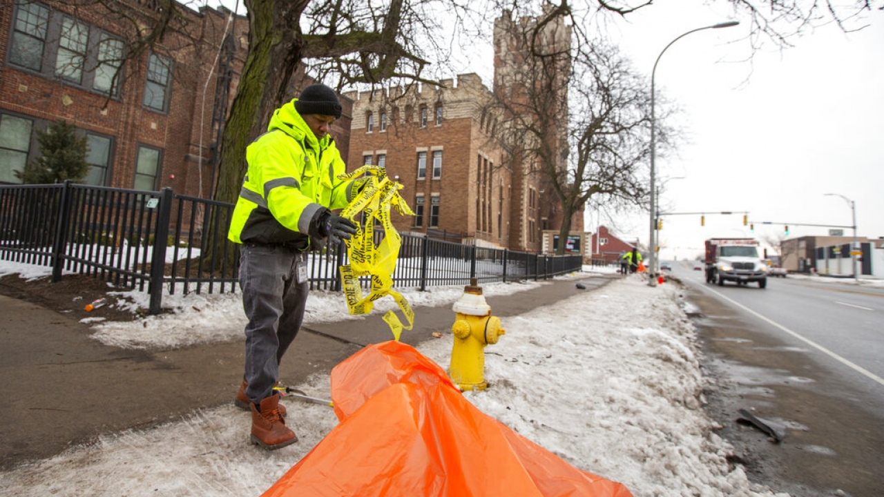 An employee with the City of Rochester cleans up police tape outside Main Street Armory after a concert ended in a stampede.