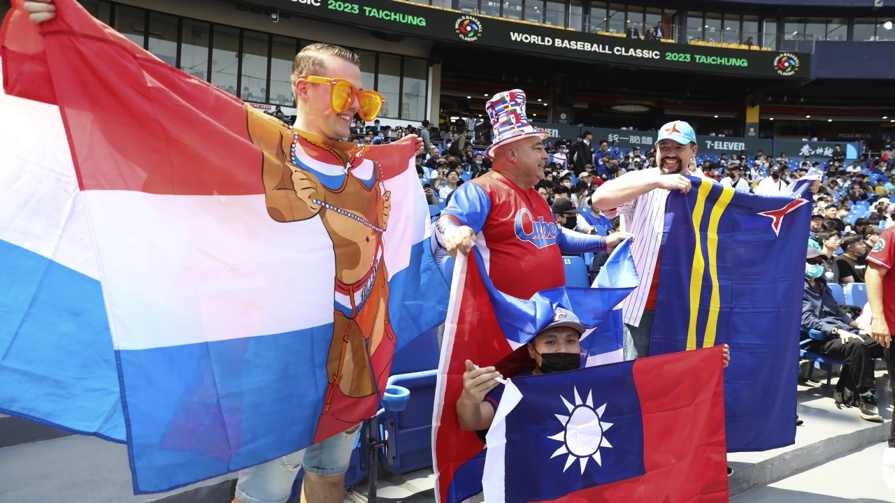 Baseball fans hold national flags of Cuba, Taiwan and Netherlands at a World Baseball Classic game.