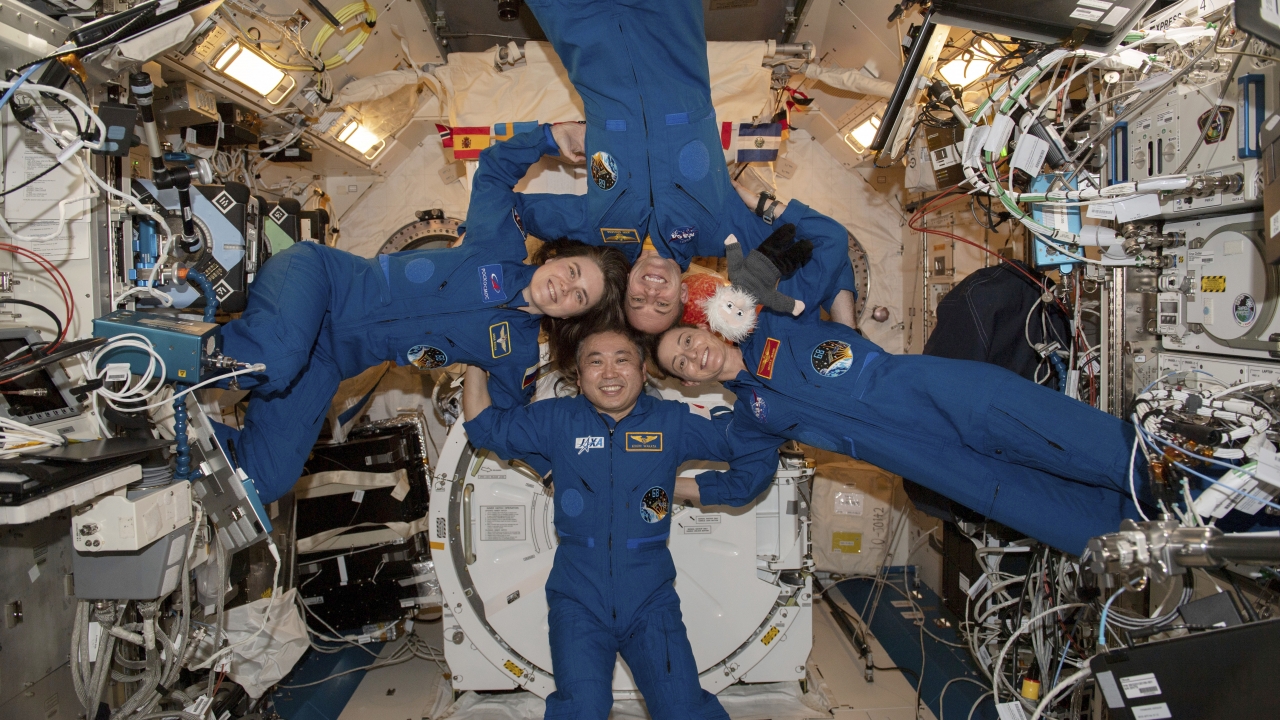 Four astronauts gather for a portrait inside the International Space Station's Kibo laboratory module