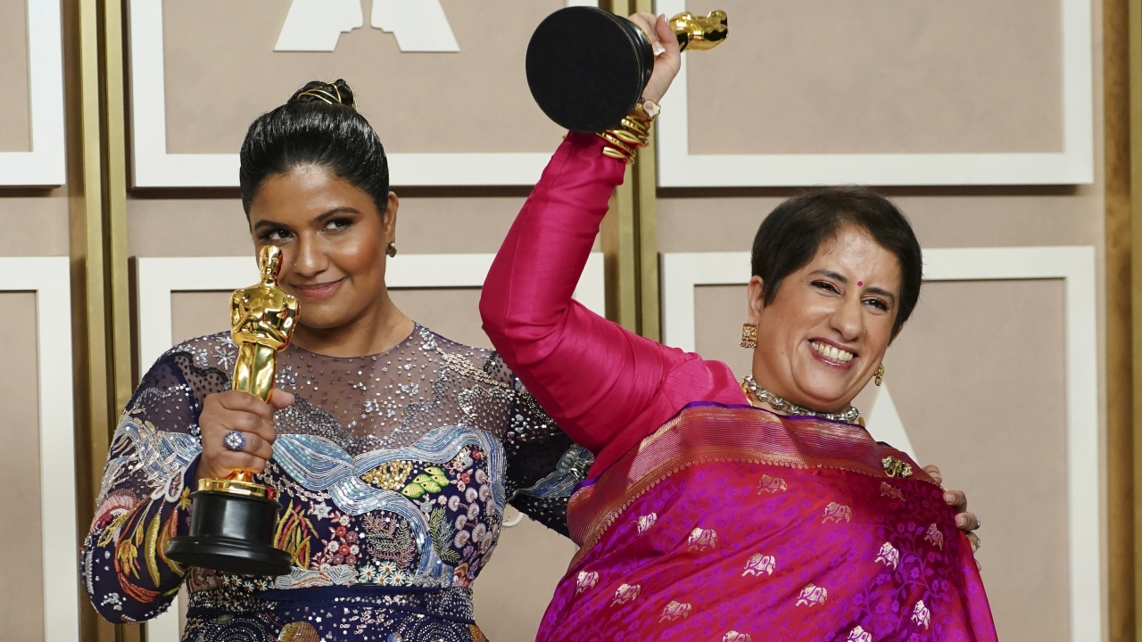 Kartiki Gonsalves, left, and Guneet Monga pose with Oscar awards