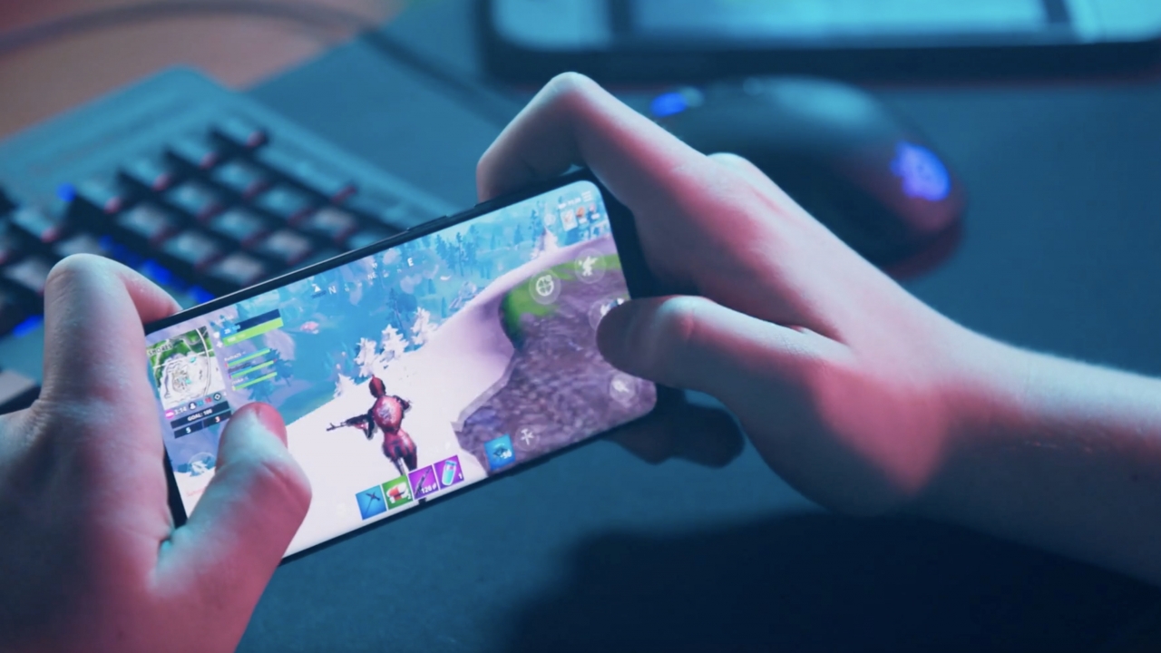 Person playing the video game Fortnite on a mobile device.