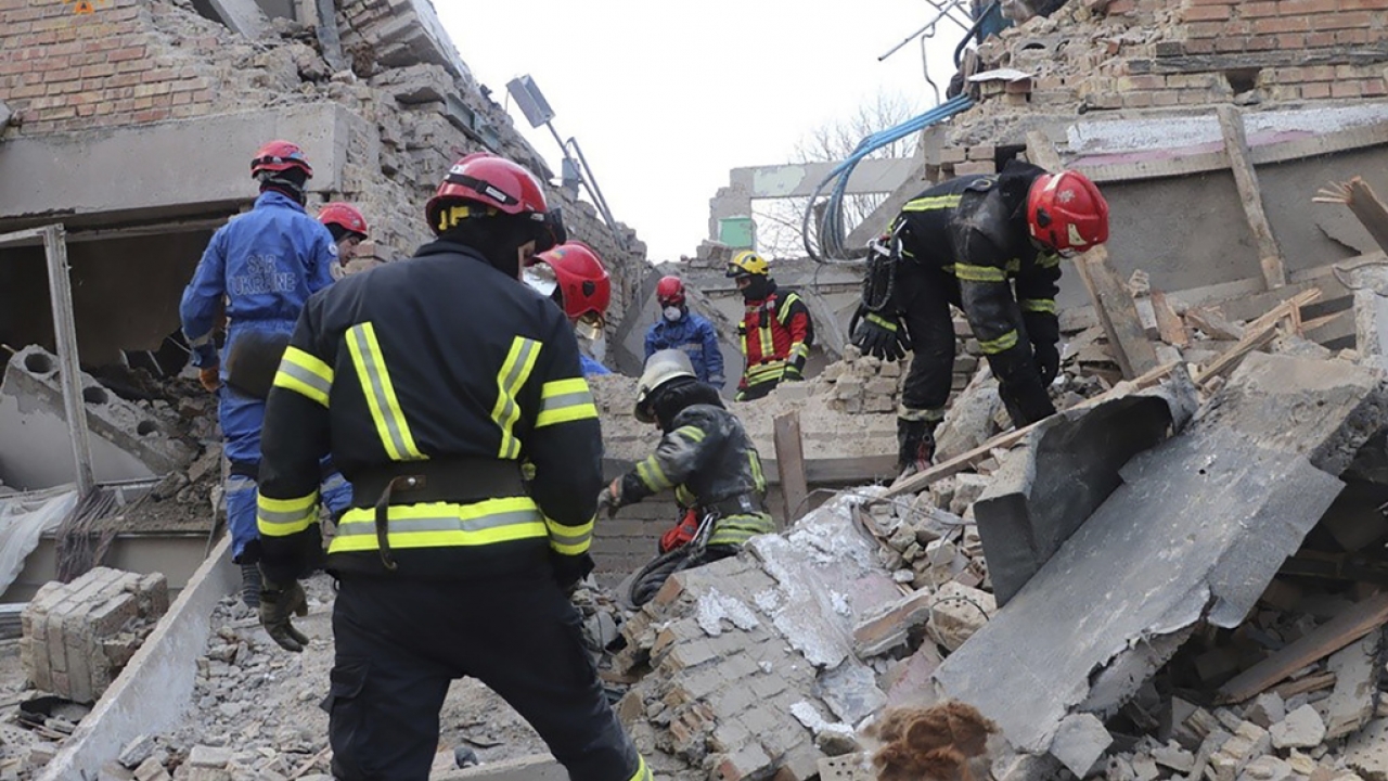 Emergency personnel work over rubble following a drone attack at a Ukraine dorm