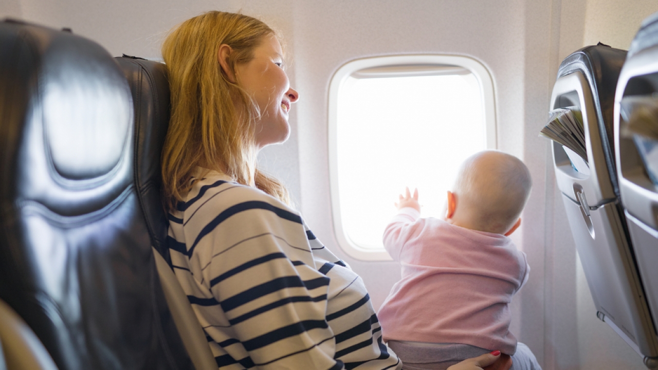 Woman and baby in an airplane seat.