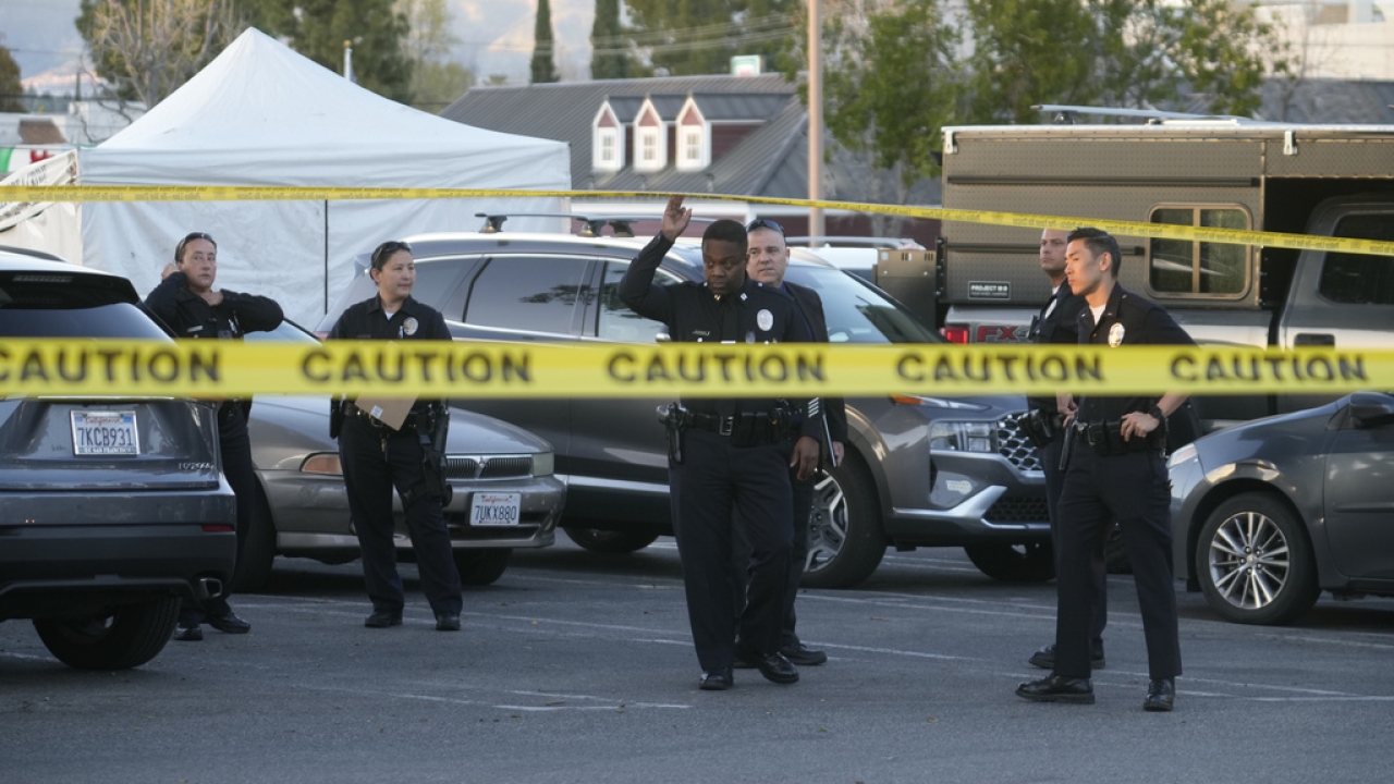 Los Angeles police investigate the scene of a fatal shooting in a shopping center parking
