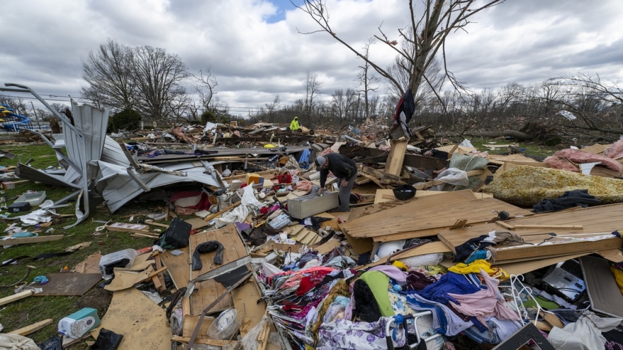 People walk through damage from a late-night tornado in Sullivan, Indiana.