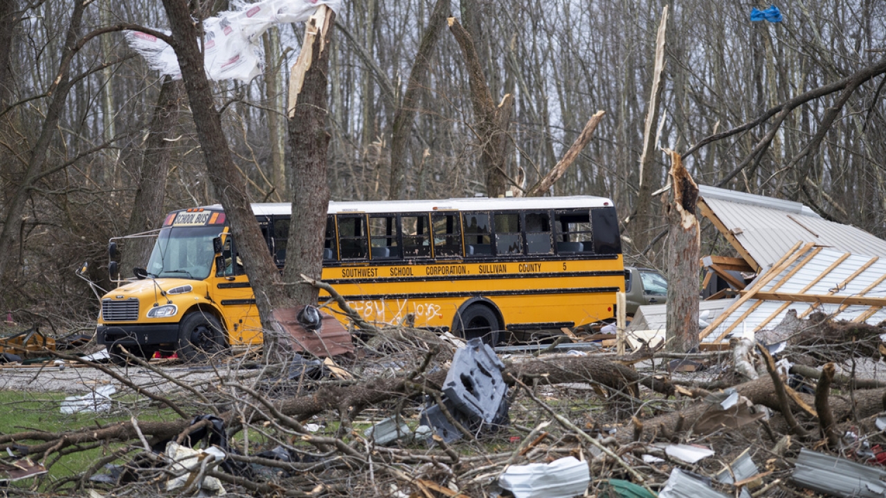 A school bus is surrounded by debris in an area that was heavily damage by a tornado in Sullivan, Ind.