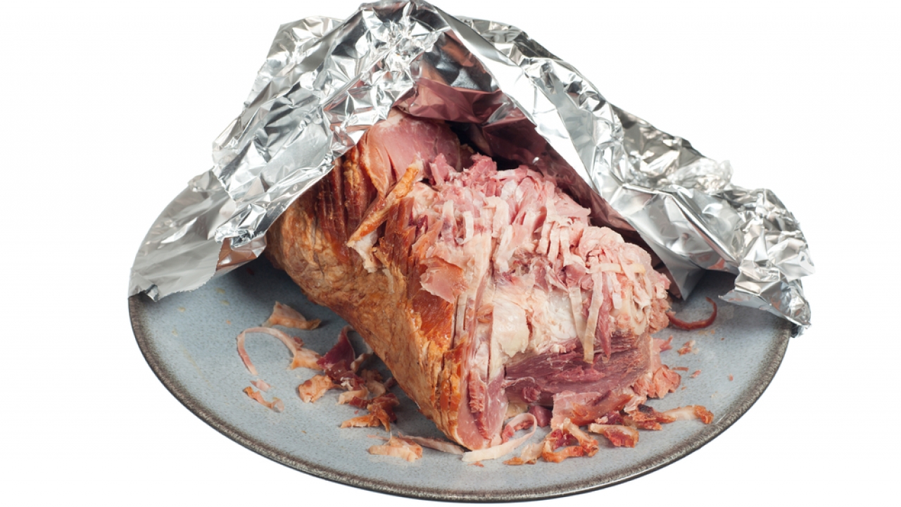 Leftover ham on a plate with aluminum foil
