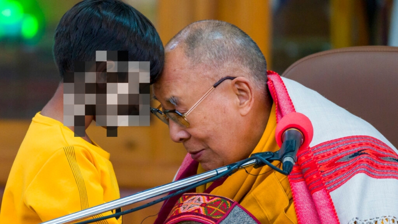Tibetan spiritual leader the Dalai Lama touches foreheads with a young boy in Dharamshala, India