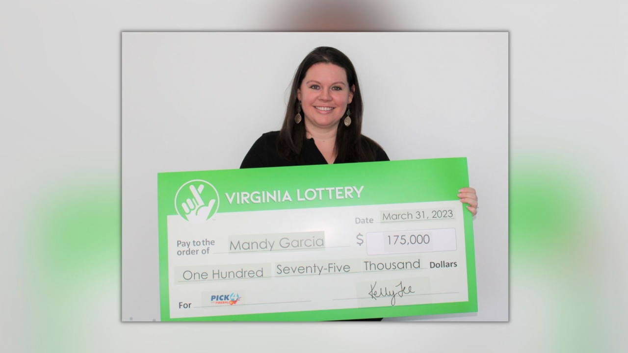 A woman holds a giant check for her $175,000 lottery winnings