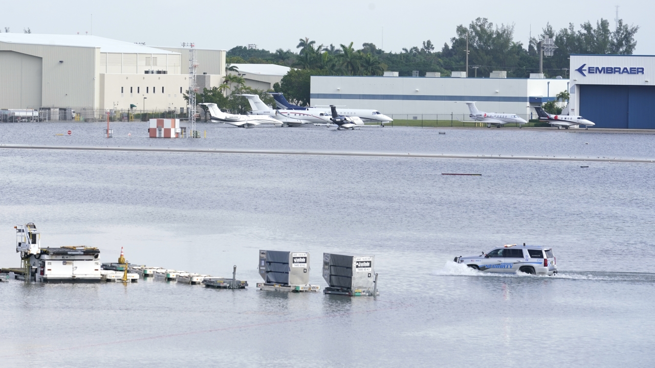 A truck drives on the flooded runway at Fort Lauderdale- Hollywood International Airport.