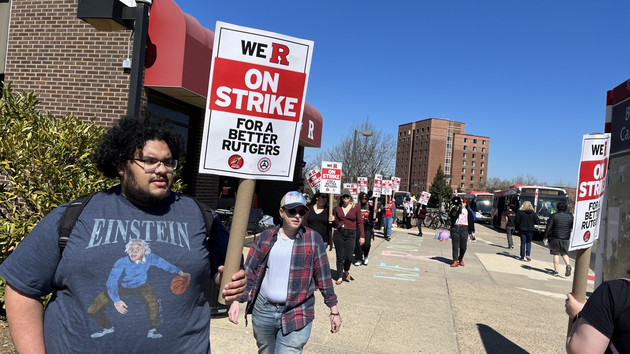 Jonathan Romero, a junior at Rutgers, joins faculty in picketing.