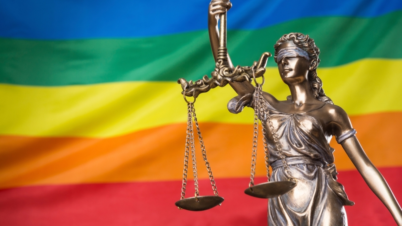 Scales of justice with a rainbow flag