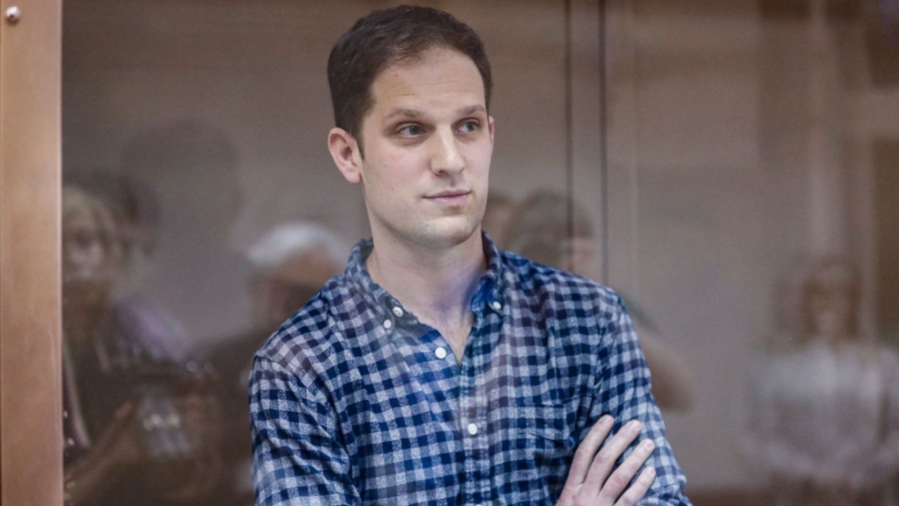 Evan Gershkovich stands in a glass box in a Russian court