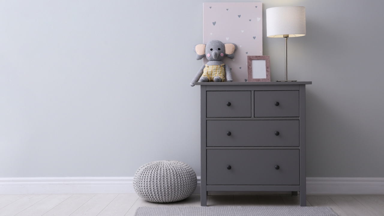 Child's dresser with stuffed animal and lamp on top