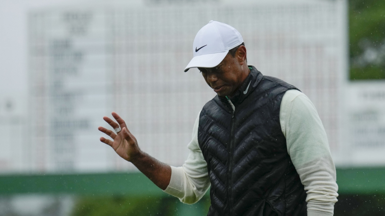 Tiger Woods waves after his weather delayed second round of the Masters golf tournament.