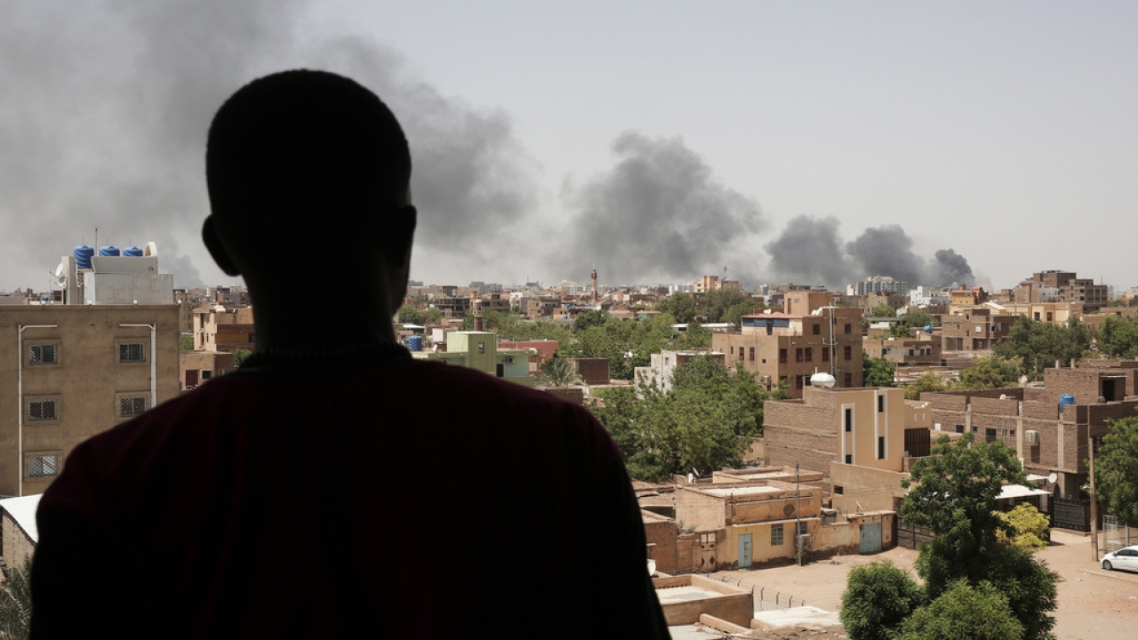 A silhouette of a person is seen overlooking smoke in Khartoum, Sudan.