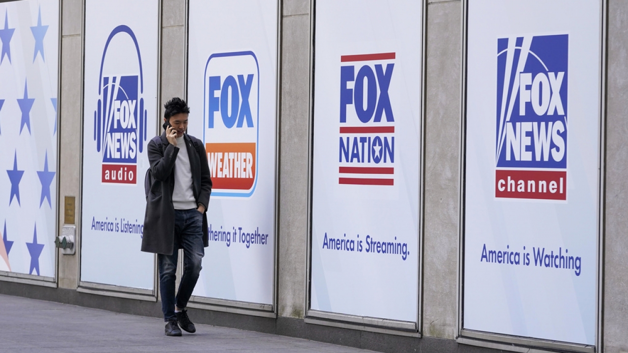A man walks past the News Corp. and Fox News headquarters.