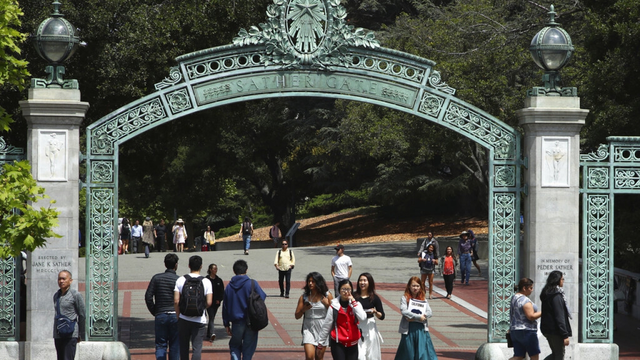 Students walk past Sather Gate on the University of California.