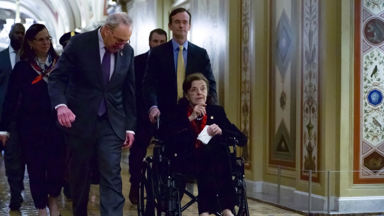 Sen. Dianne Feinstein is pushed in a wheelchair, accompanied by Senate Majority Leader Chuck Schumer, at the U.S. Capitol.