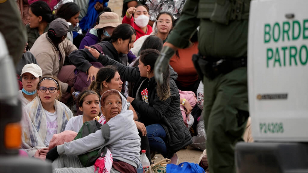 A U.S Customs and Border Protection official with migrants.