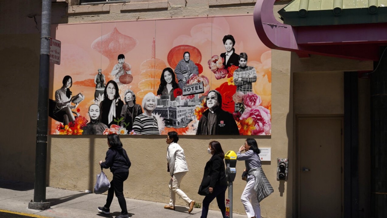 A group of women walk up Jackson Street in Chinatown past the new AAPI Community Heroes mural in San Francisco