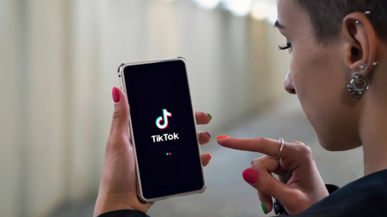 Woman opens the TikTok app on a mobile device.