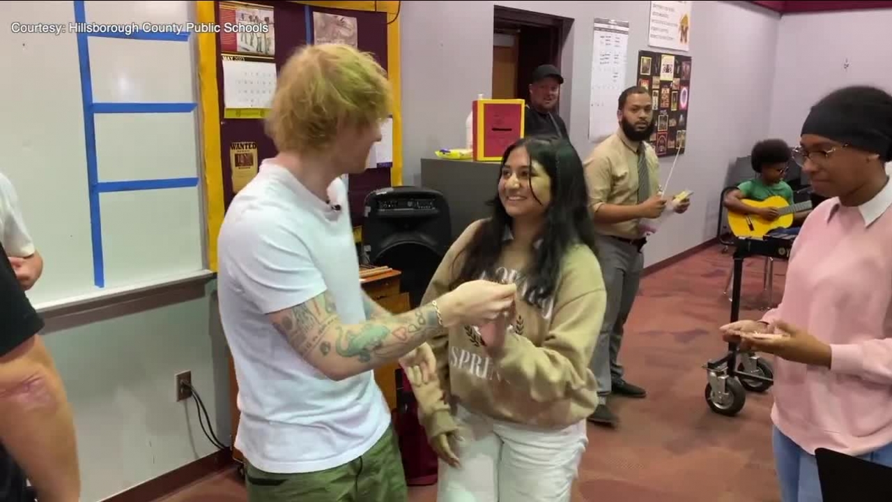 Ed Sheeran interacts with a student band member.