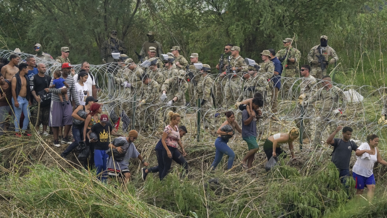Texas National Guardsmen reinforce a stretch of razor wire as migrants try to cross into the U.S.