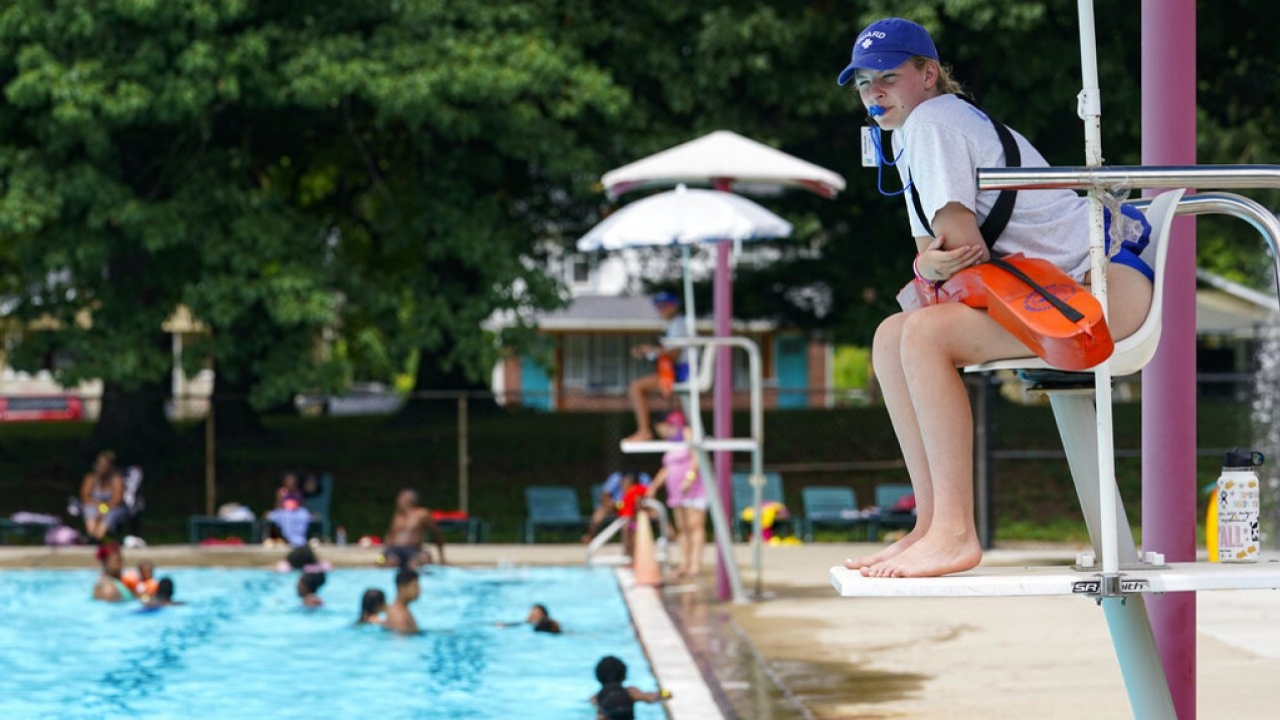 A lifeguard keeps an eye on swimmers at a pool