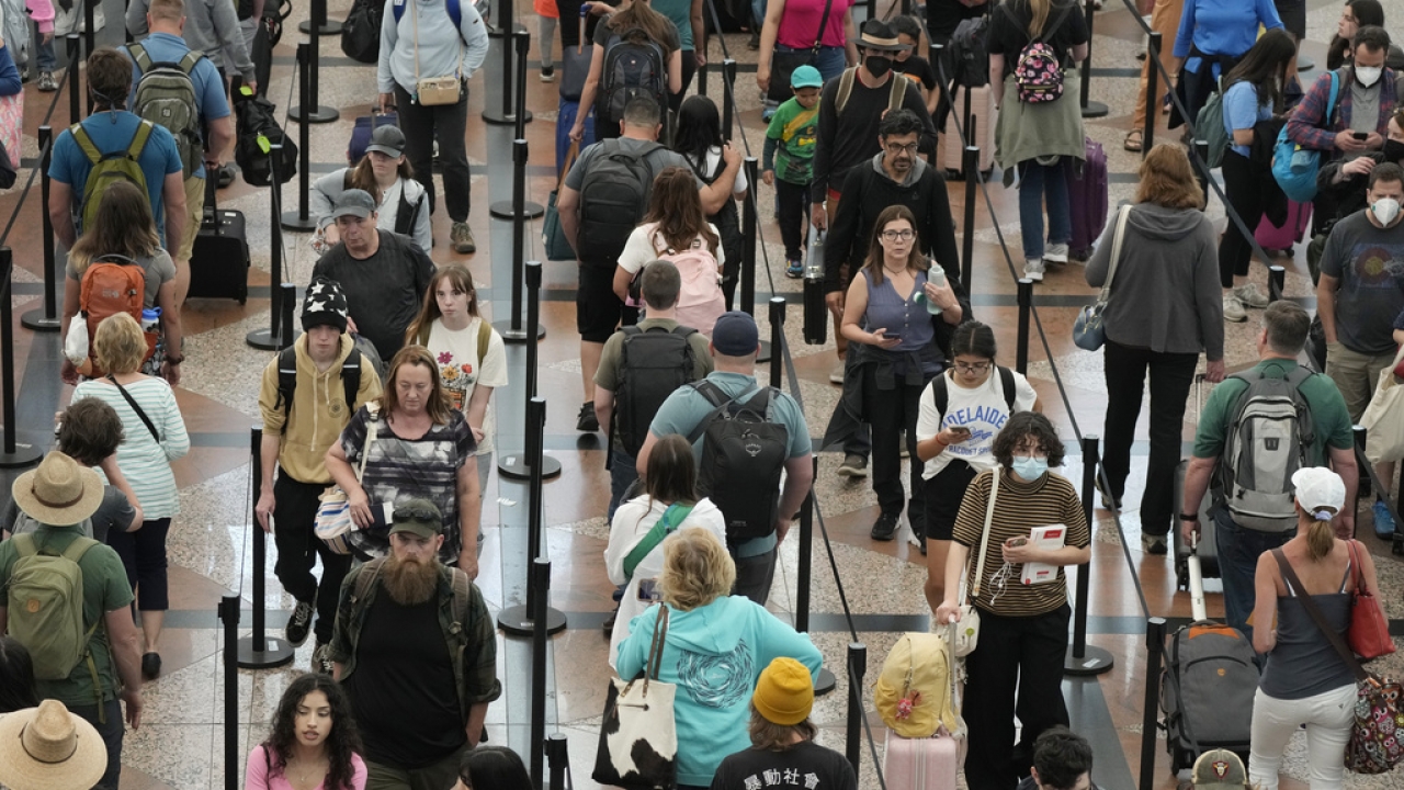 Travelers move through a security checkpoint in Denver International Airport.