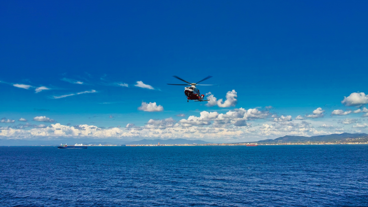 A medical helicopter flies over water