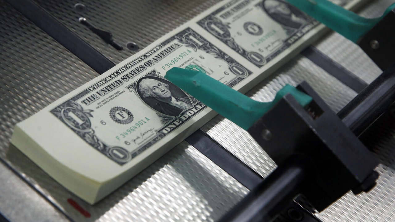 New $1 bills are cut and stacked.