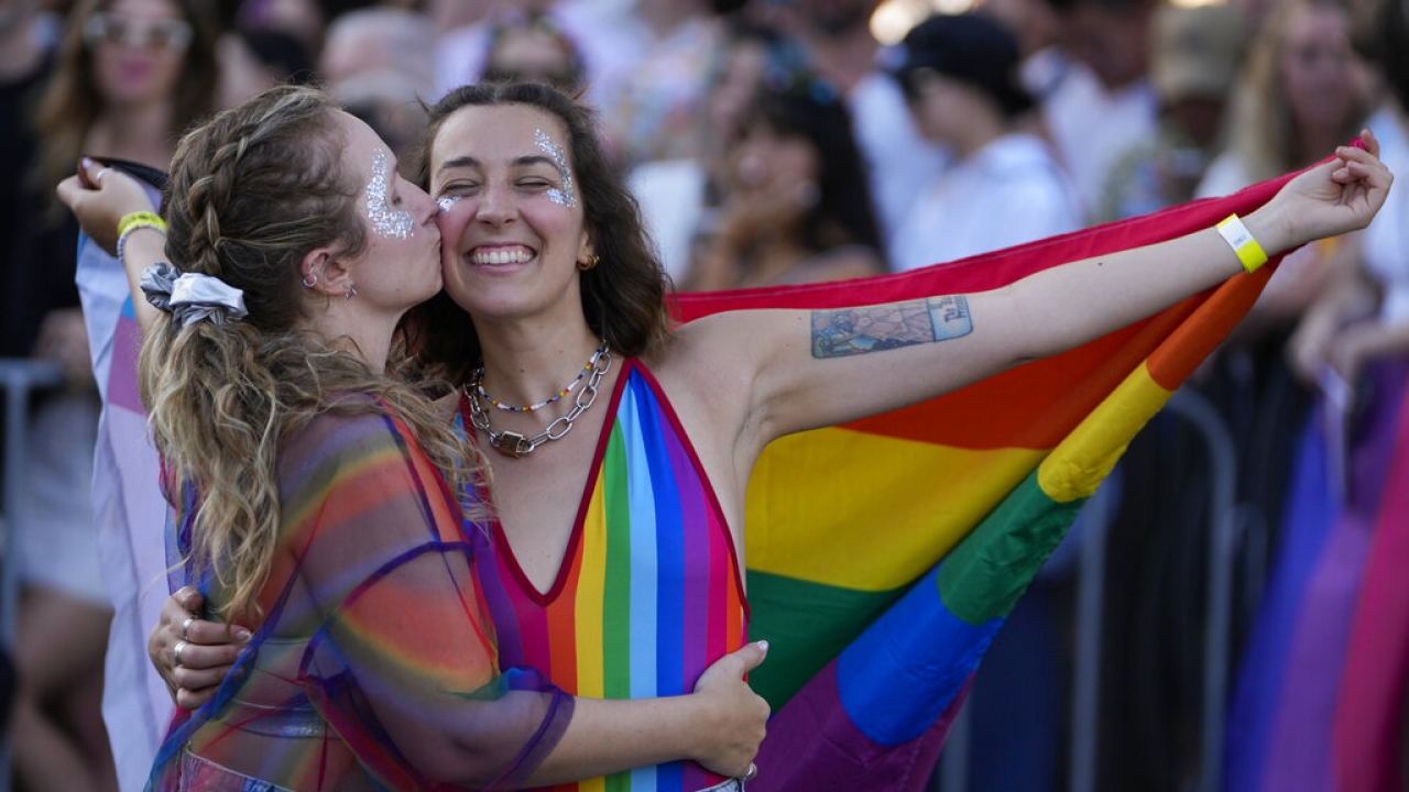 Spectators embrace ahead of the start of the 45th anniversary Sydney Gay and Lesbian Mardi Gras.