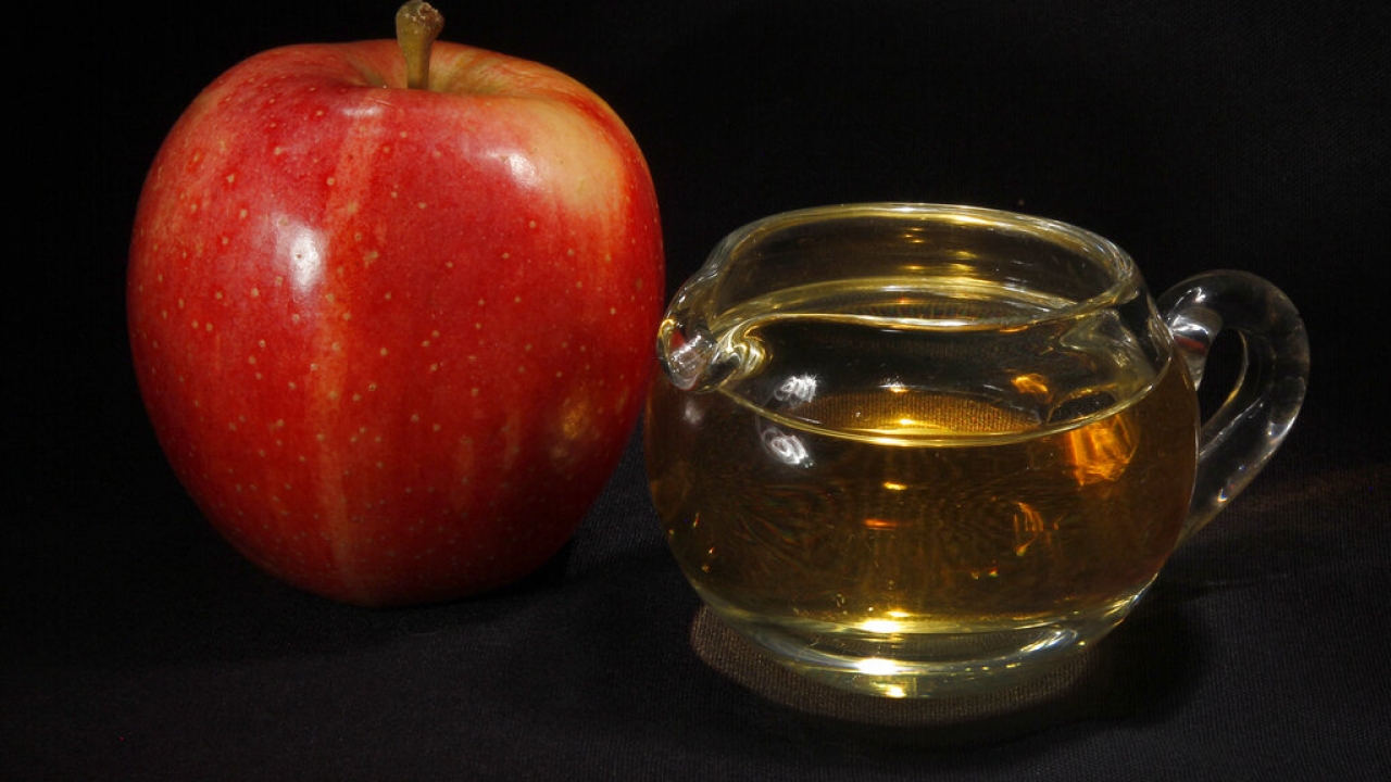 An apple next to apple juice.