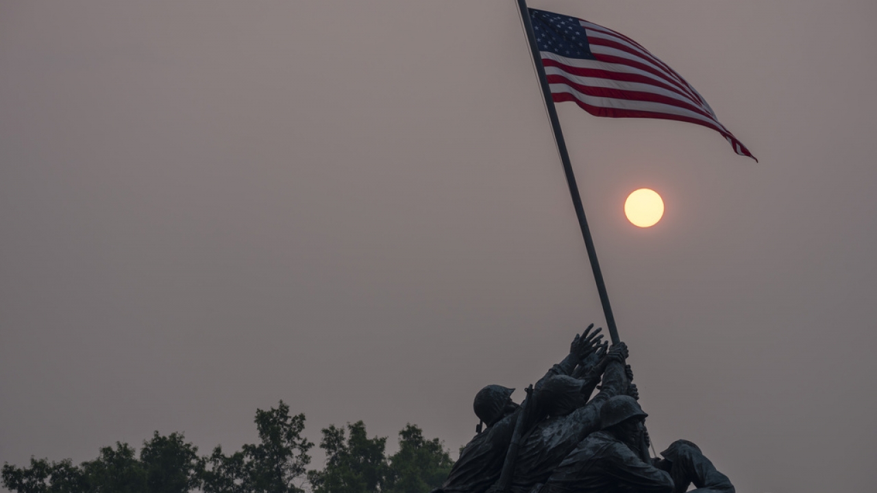 Haze blankets the United States Marine Corps War Memorial in Washington, D.C., as the sun rises.