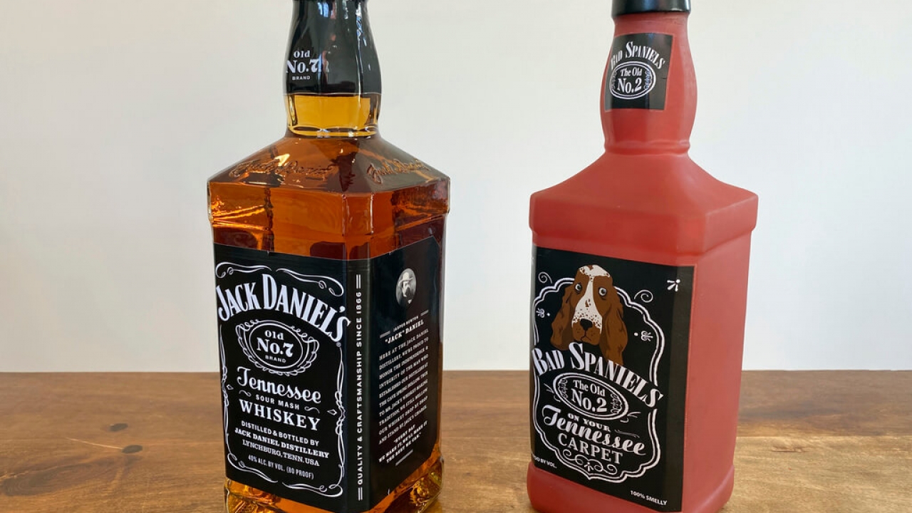 A bottle of Jack Daniel's Tennessee Whiskey is displayed next to a Bad Spaniels dog toy.