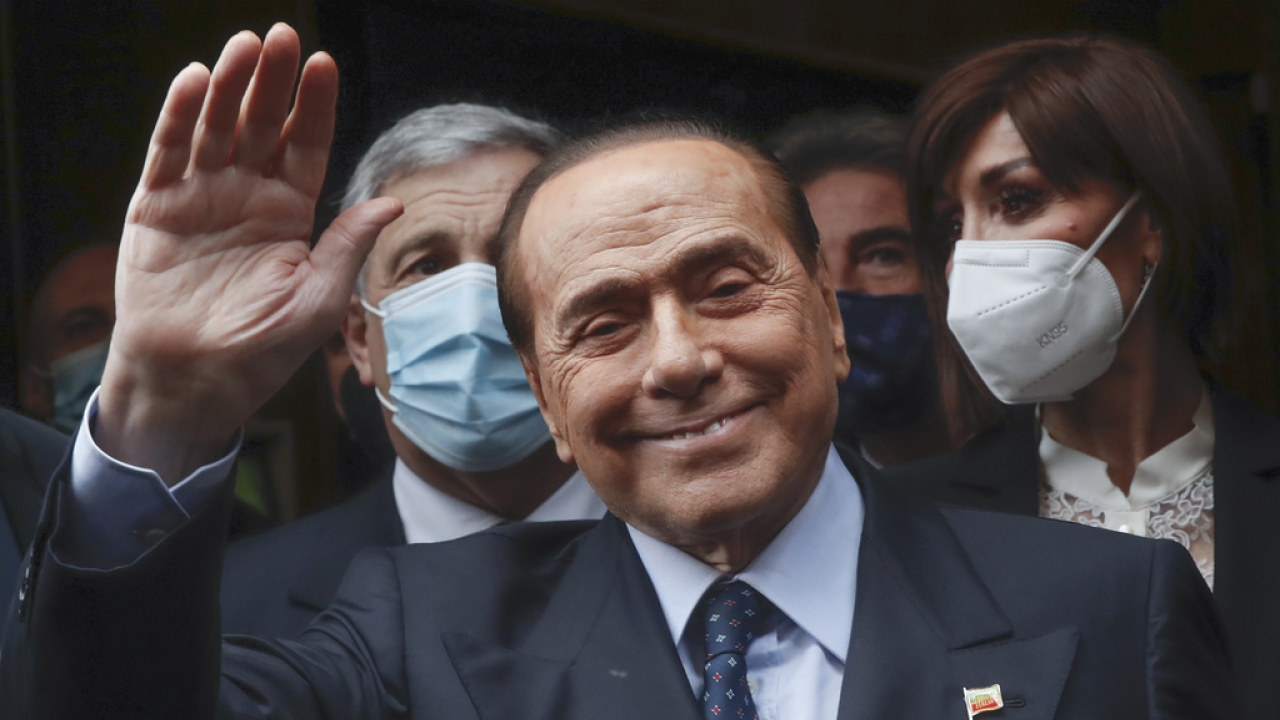 Former Italian Premier Silvio Berlusconi waves to reporters.