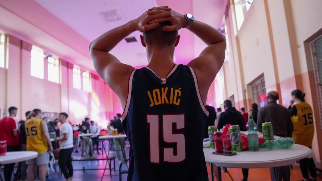Denver Nuggets fan in a Nikola Jokic jersey celebrates the team's NBA Finals victory.