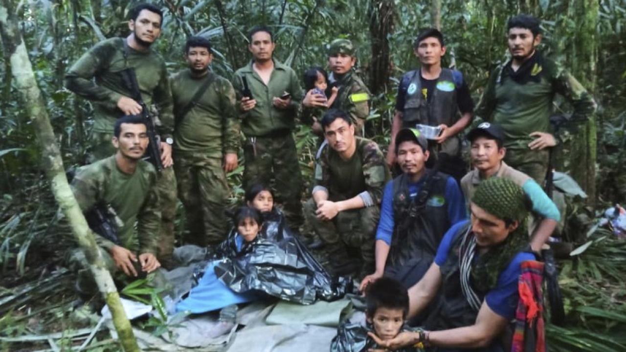 Soldiers and Indigenous men pose for a photo with the four children who were missing.