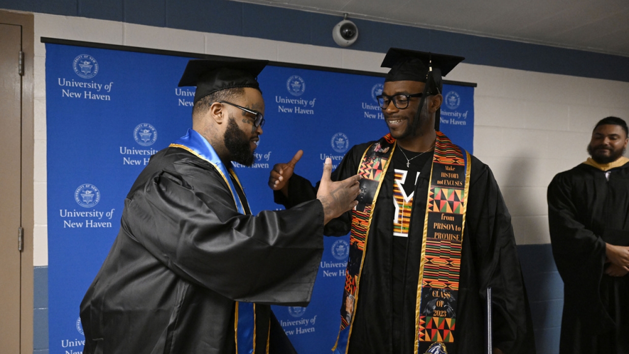 College graduates Alpha Jalloh, left, and Marcus Harvin, right, congratulate each other.