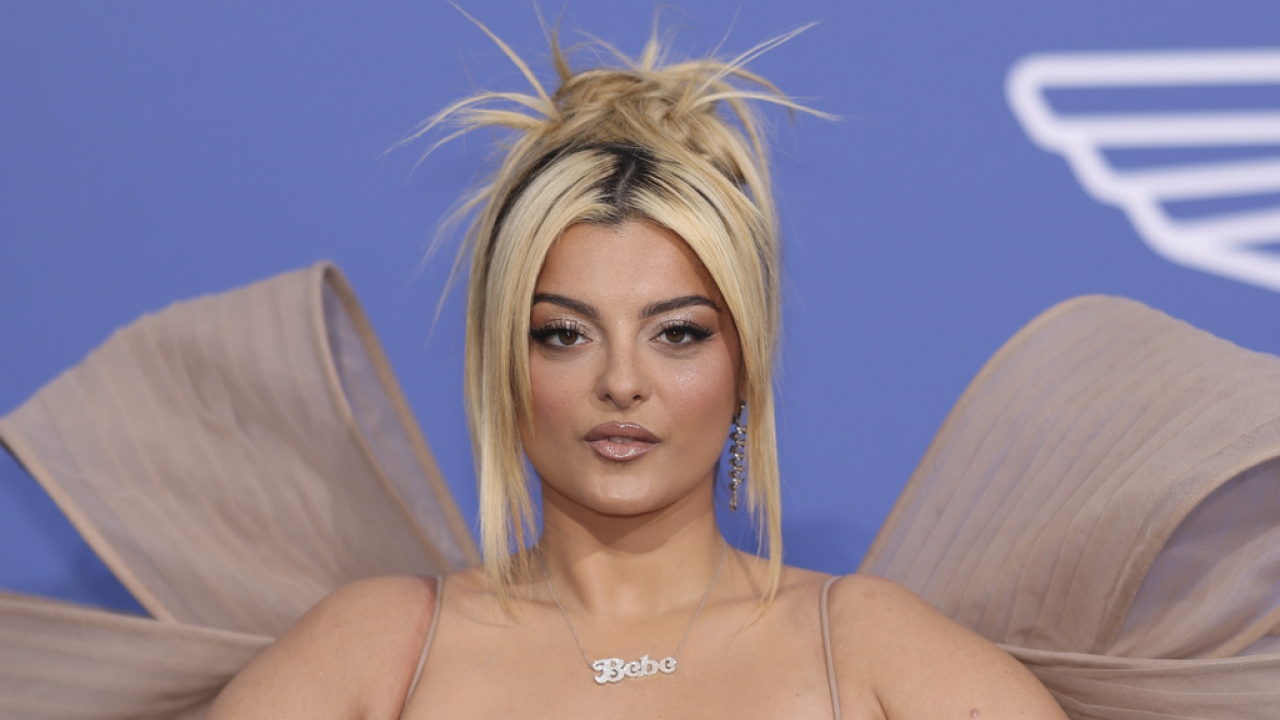 Bebe Rexha poses on a red carpet.